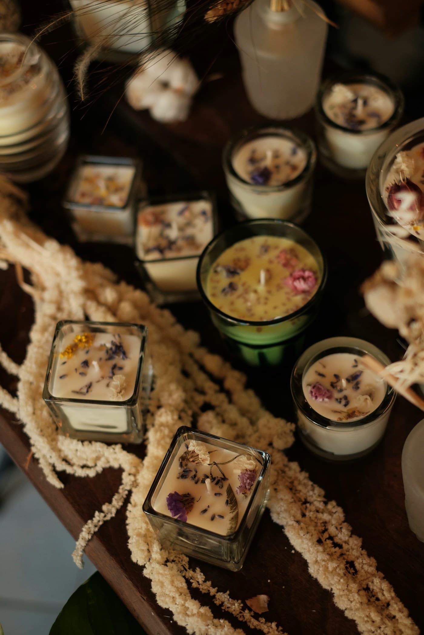 Rows of finished candles with dried flowers set in the wax